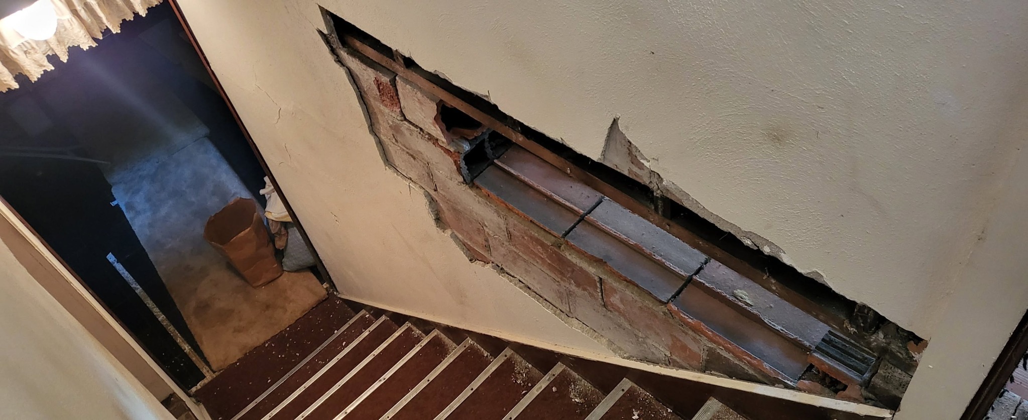 Wall opened for repair beside an interior staircase