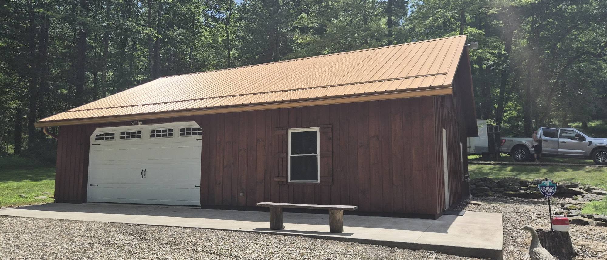Finished red wood outbuilding with white garage door