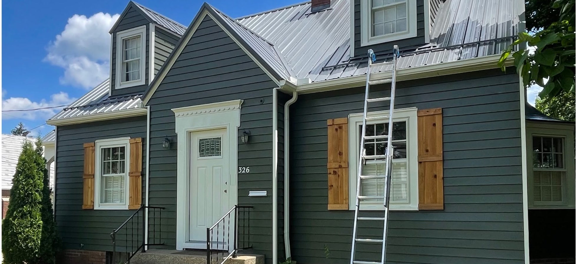 Charcoal-painted home with crisp white trim and natural wood shutters